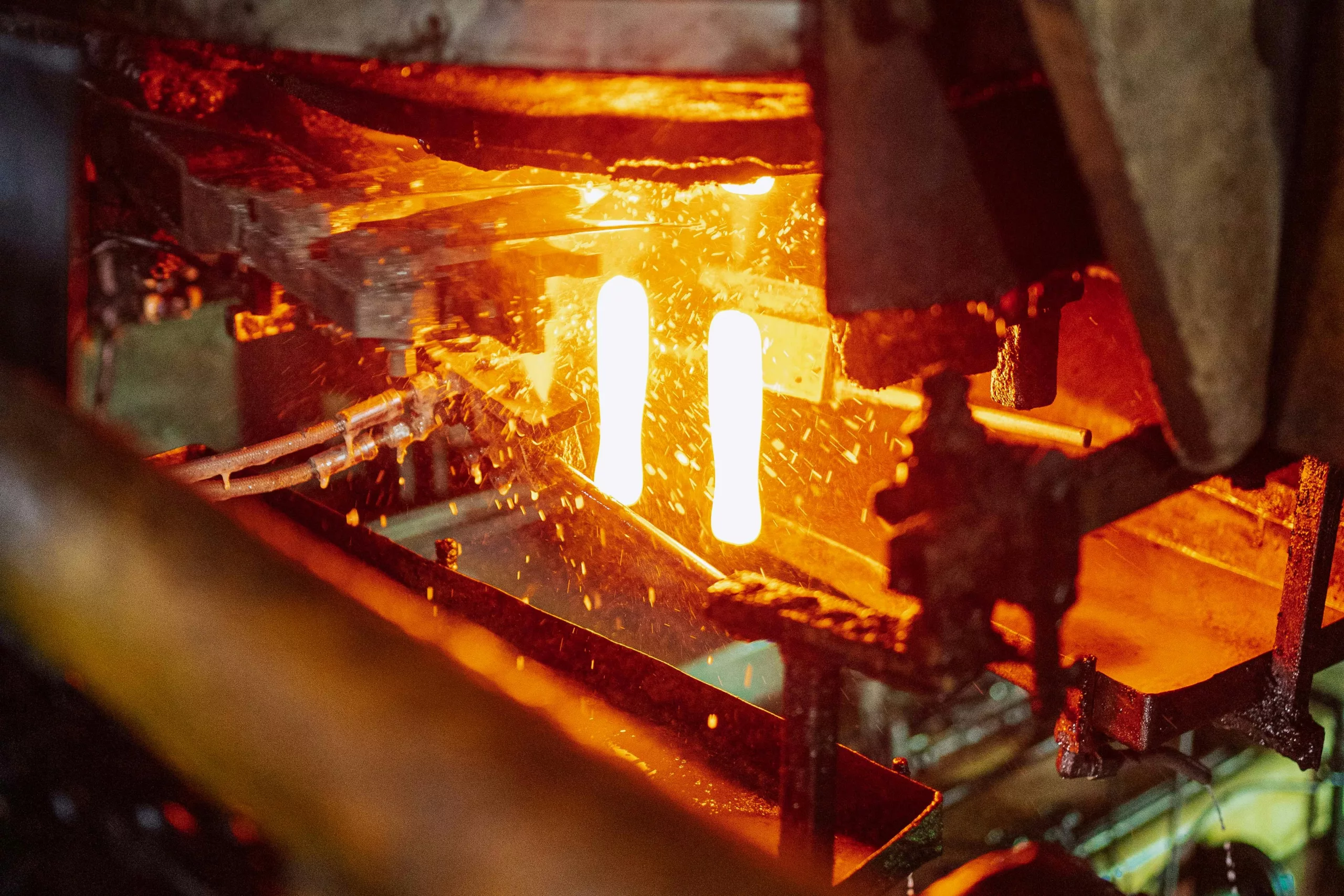 Steel Forging -Glassblowing process in a Tanzanian factory showcasing molten glass formation.